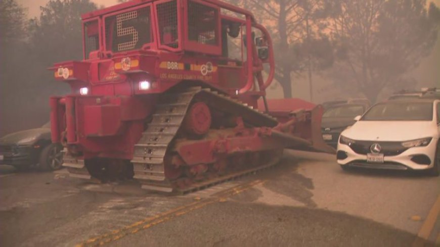 Officials use bulldozer to shove abandoned vehicles out of the way near Los Angeles fire